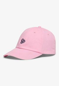 Light pink baseball cap with a black embroidered stylized letter logo on the front, six-panel design, and curved brim.