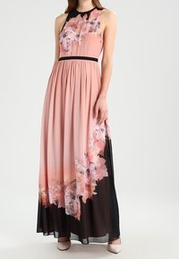 Maxikleid aus weichem pinken Stoff mit Blumenmuster und schwarzen Akzenten. Verfügt über ein tailliertes Oberteil, einen plissierten Rock und ein ärmelloses Design.