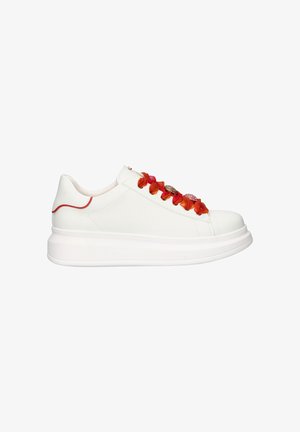 Zapatilla deportiva de plataforma blanca con detalles de encaje floral en rojo anaranjado brillante y sutil detalle rojo en la lengüeta del talón, vista lateral.
