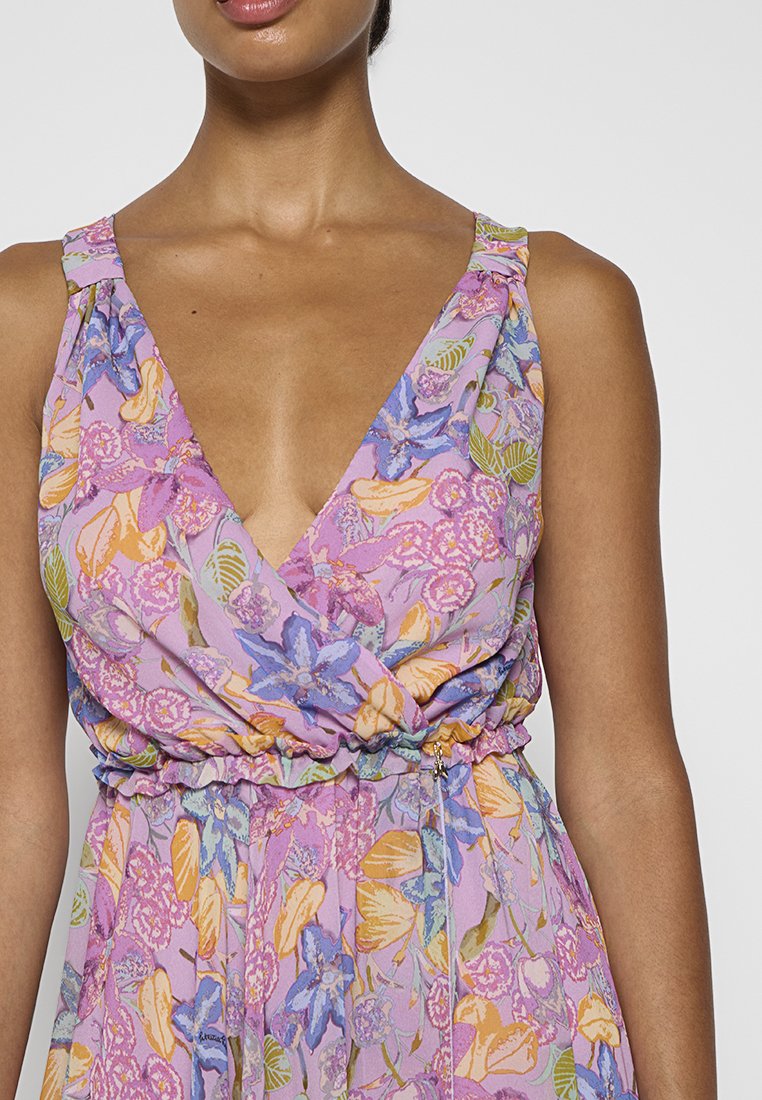 Sukienka z dekoltem w serek i szerokimi ramiączkami, z kwiatowym wzorem w odcieniach purpury, niebieskiego, żółtego i zielonego. Elastyczna talia z marszczonym wykończeniem.