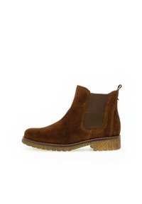 Stivaletto in suede marrone con pannelli elastici ai lati, punta rotonda e suola in gomma testurizzata per una migliore aderenza. Tacco basso e impilato.