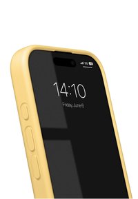 Yellow phone case with a black screen, displaying time and date. Side buttons visible; sleek design and smooth texture. 5G signal indicator.