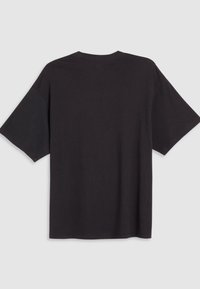 Sort oversized t-shirt lavet af bomuld. Korte ærmer, rund halsudskæring og en ensartet tekstur uden synlige grafik eller udsmykninger.