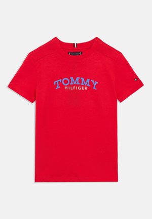 Rood katoenen T-shirt met korte mouwen, met de tekst "TOMMY HILFIGER" in blauw. Voorzien van een klein logo-accent op de mouw.