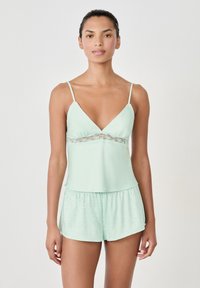 Conjunto de pijama verde menta que incluye un camisón con ribete de encaje y pantalones cortos a juego con un patrón texturizado y cintura elástica.