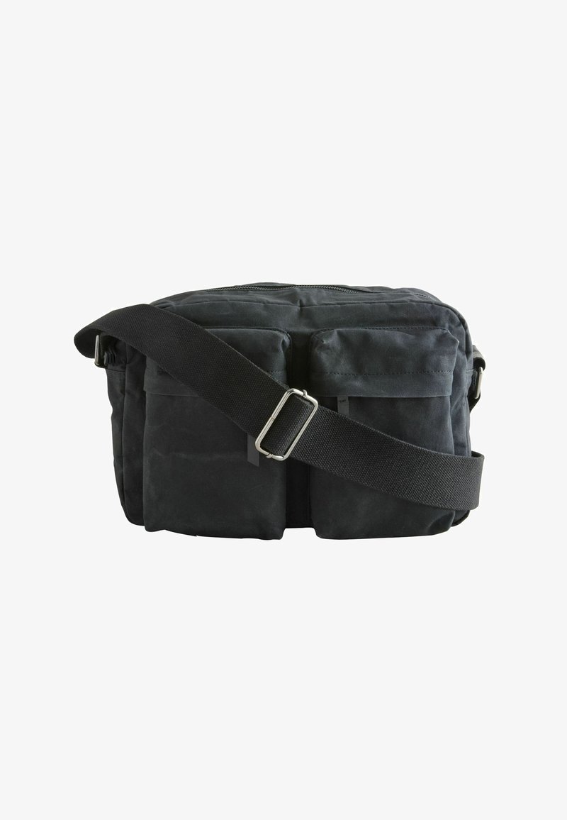 Borsa a tracolla nera in tessuto con due tasche frontali, cuciture rinforzate, tracolla regolabile e chiusura superiore con zip.