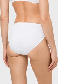 Weiße Baumwollunterwäsche mit hohem Bund, glatter Textur, elastischem Bund und gewellten Besatzdetails an den Rändern.