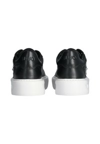 Sneakers in pelle nera con suole in gomma bianca. Presentano un logo embossato sul tallone e una superficie liscia con dettagli di cucitura ridotti al minimo.