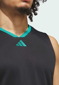 Maglia da allenamento nera senza maniche con colletto a V teal e logo Adidas teal sul petto. Realizzata in tessuto leggero e liscio.