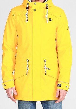 Veste de pluie jaune à capuche avec cordons blancs et noirs, poignets boutonnés, poches avant et petit logo sur la poitrine et la manche.