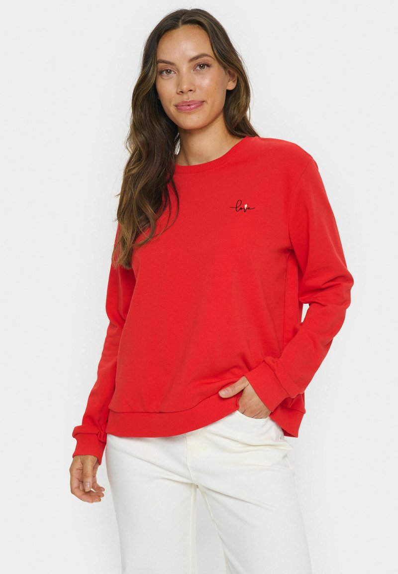 Rotes Sweatshirt mit rundem Ausschnitt, langen Ärmeln und einem Saum. Hat eine kleine schwarze "love"-Stickerei auf der Brust. Glatte Textur.