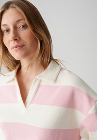 Trui met kraag, met horizontale roze en witte strepen, gemaakt van een zachte, gestructureerde stof.