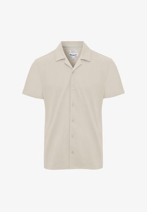 Camisa beige de manga corta con botones, con un corte regular y un cuello clásico, mostrada sobre un fondo blanco.