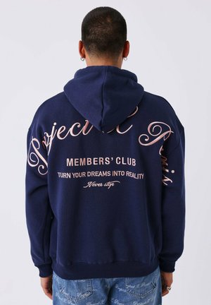 Sudadera azul marino con capucha ajustable; presenta texto en color rosa en la espalda. Material suave de algodón; corte relajado con puños y dobladillo acanalados.