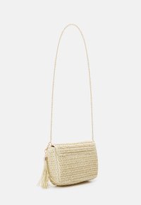 Pleciona torebka na ramię z trawy morskiej w jasnobeżowym kolorze, z złotym łańcuszkiem i ozdobnym chwostem z boku. Prostokątny kształt z teksturowanym wykończeniem.