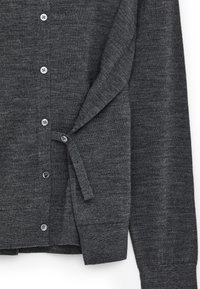 Cardigan boutonné gris foncé à manches longues avec un détail de bouton sur une bride latérale sur fond blanc.