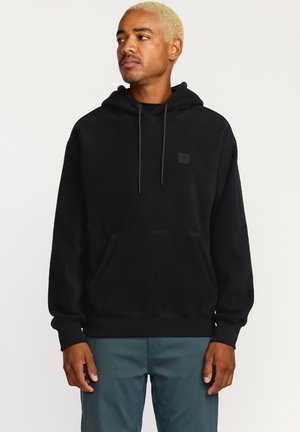 Zwarte fleece hoodie met een voorzak, verstelbare koordjes en een klein logo patch. Beschikt over lange mouwen en geribde manchetten.