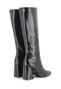 Un par de botas de cuero negras hasta la mitad de la pantorrilla con tacones de bloque y puntas afiladas, mostrando vistas trasera y lateral sobre un fondo blanco.
