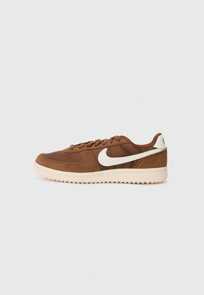 Bruine suède en mesh sneaker met een witte swoosh-logo, ronde neus, platte veters en een textuur met een crèmewitte rubberen zool.