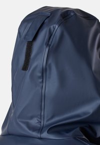 Mörkblå vattentät ryggsäck med en slät, glänsande yta. Har en kardborrematchning och sömdetaljer som visar en stilren, minimalistisk design.