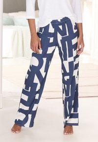 Navy blue pajama pants featuring large white alphabetic characters in a bold pattern, with an elastic waistband and loose fit.