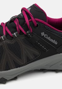 Chaussure de trail Columbia noire et grise avec lacets et doublure intérieure rose foncé, empeigne en mesh et semelle en caoutchouc texturée.