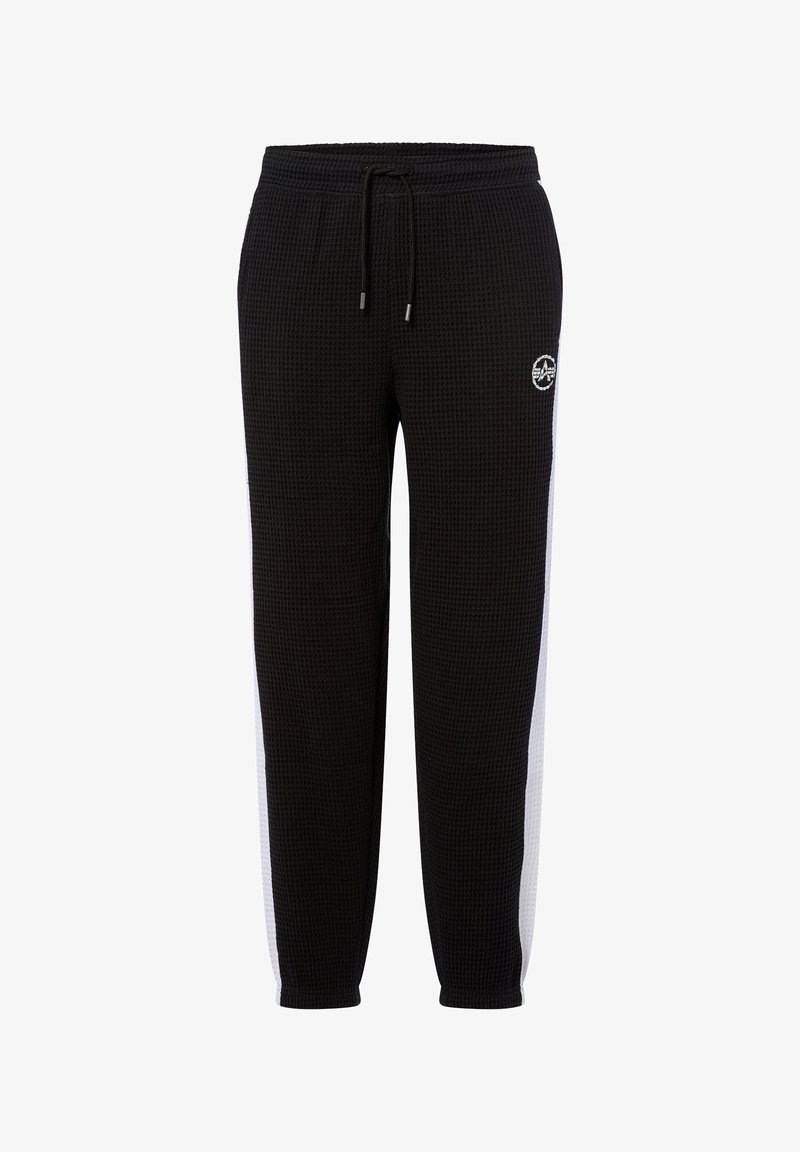 Pantalones de chándal negros con textura, con franjas laterales blancas, cinturilla elástica, cordón y pequeño logo circular en el muslo izquierdo.