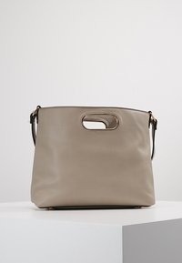 Beige nahkalaukku, jossa on teksturoitu pinta, yläkahva ja irrotettava olkahihna. Ominaisuuksiin kuuluu pieni soikea leikattu kahva.