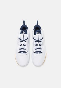 Witte sportieve schoenen met marineblauwe accenten, met een gestructureerde bovenkant, ronde veters en een zool van rubber. Inclusief trekriempjes op de hiel.