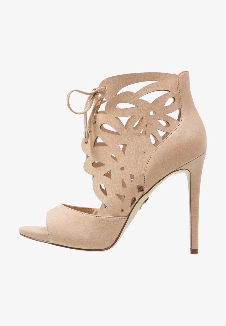 Sandale beige à talon haut, décor floral découpé au laser, bout ouvert, laçage à l'avant et talon aiguille.