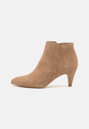 Taupe Wildleder-Ankle-Boot mit einer spitzen Zehe und einem schlanken, mittelhohen Absatz. Verfügt über einen seitlichen Reißverschluss und eine glatte Textur.