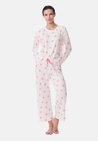 White pajama set with long sleeves and pants, featuring a repeated pink lip print and an elastic waistband with a pink drawstring.