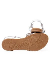 Sandalo bianco con cinturino, dotato di un cinturino grigio chiaro e suola in gomma marrone con un motivo a rosa in rilievo. Design antiscivolo, prodotto in Spagna.