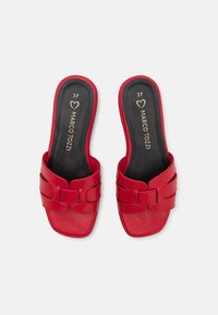Sandales rouges à glissière en matériau synthétique lisse, avec une semelle plate, des larges bandes sur le dessus et un design à bout carré.