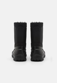 Botas impermeables negras con un empeine texturizado, forro suave y una suela de goma robusta. Presentan una altura hasta el tobillo y un panel trasero reforzado.