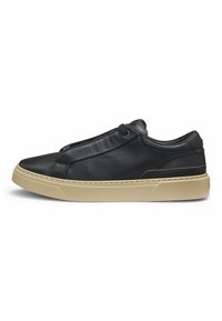 Black leather sneaker with a rounded toe, elasticized lace design, and a beige rubber sole. Features stitching accents along the sides.