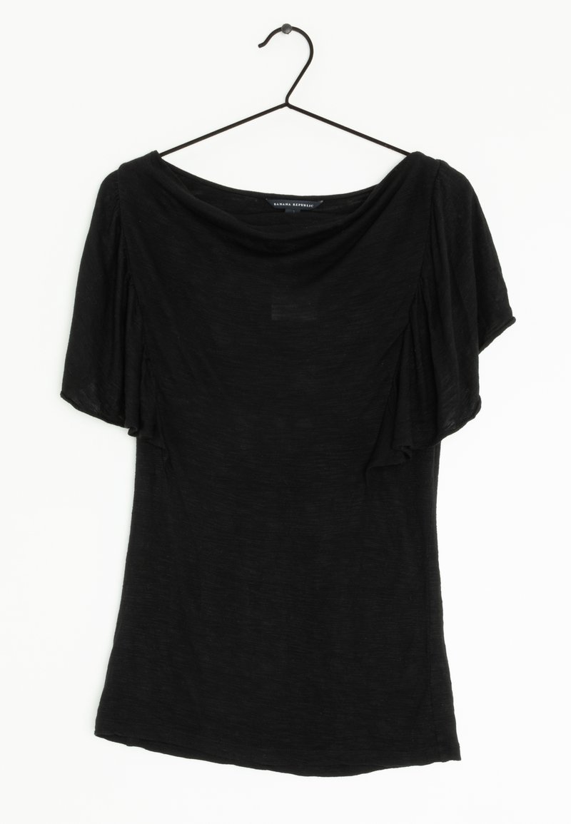 Blouse noire à manches courtes avec un large décolleté et des manches volantées, accrochée à un cintre noir fin sur un fond blanc.