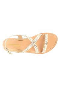 Sandal in cuoio chiaro con cinturini intrecciati in argento e chiusura a fibbia. La soletta presenta un discreto marchio impresso. Suola piatta per garantire comfort.