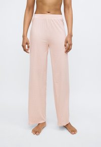 Light pink pajama pants with a subtle pattern, wide leg design, elastic waistband, and soft, lightweight fabric. Floor-length cut.