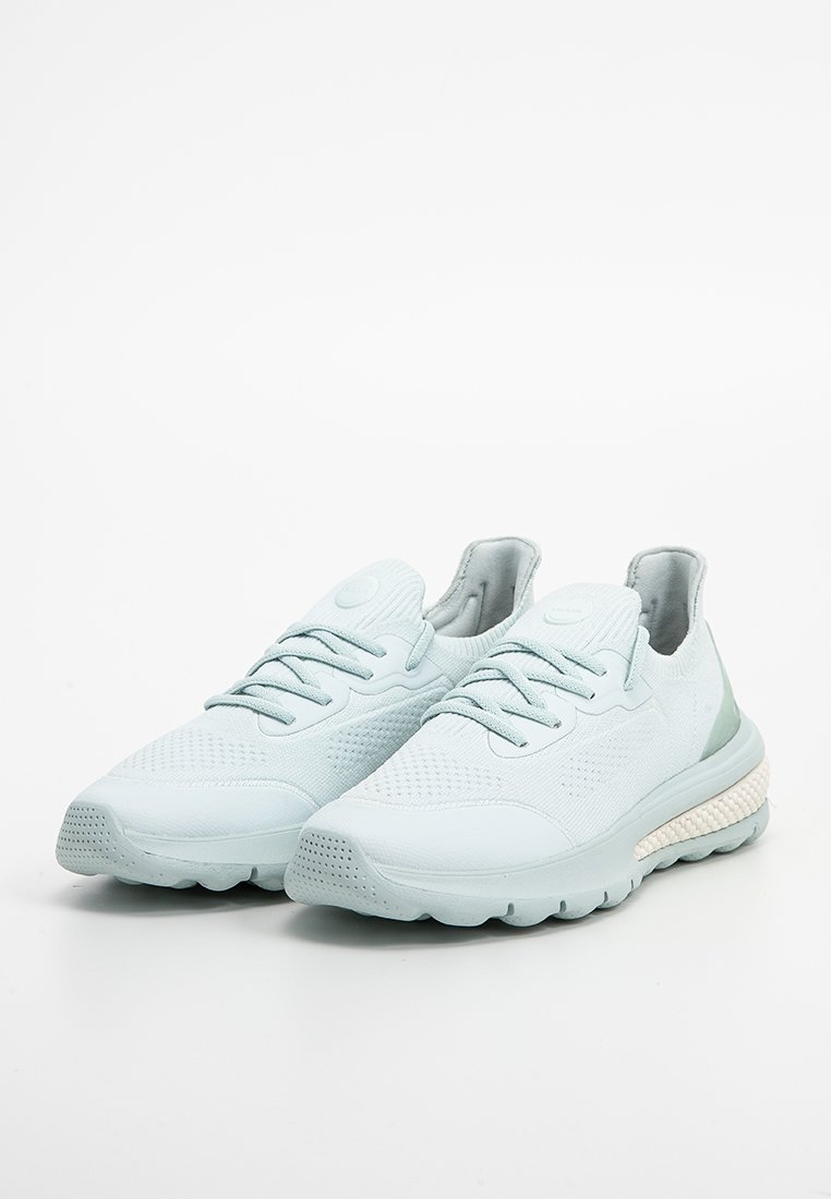 Jasnoniebieskie buty sportowe z teksturowanym górnym materiałem z dzianiny, okrągłym noskiem, płaską podeszwą i kontrastującym białym detalem w śródpodeszwie. Zawiązywane sznurówki na górze.