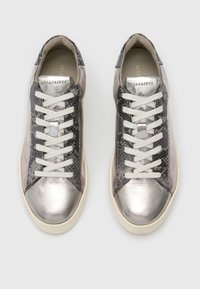 Zapatillas de cuero plateado metálico con acentos texturizados en gris oscuro y cordones blancos. Presentan una punta redonda y una suela de perfil bajo.