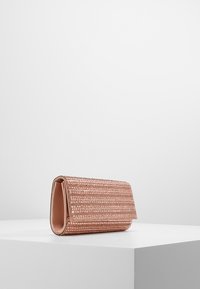 Puzdro w różowym złocie z teksturowaną powierzchnią, prostokątnym kształtem i złożonym klapą. Gładkie wykończenie wnętrza i brak widocznych elementów metalowych.