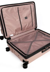 Valigia rigida rosa aperta con zip nera, scomparto in rete, tasche interne con zip e quattro ruote nere su sfondo bianco.