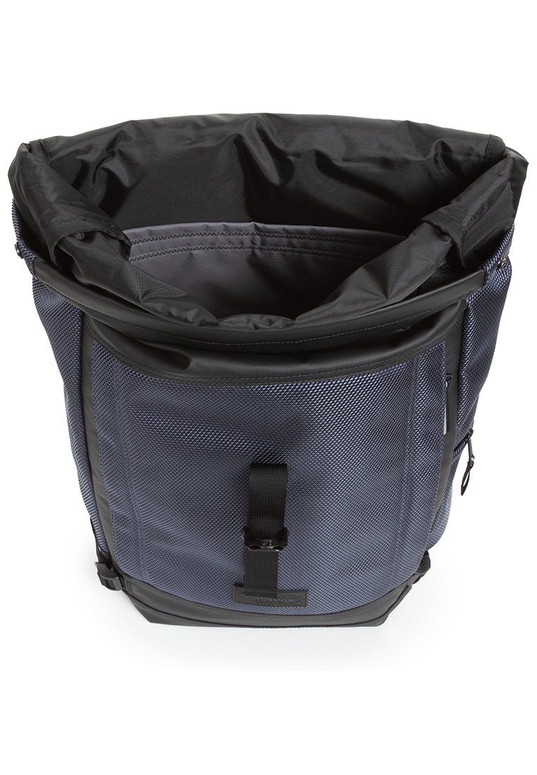 Sac à dos texturé bleu marine avec un intérieur noir, fermeture par cordon en haut et boucle avant. Comprend une poche zippée sur le côté et des bretelles robustes.