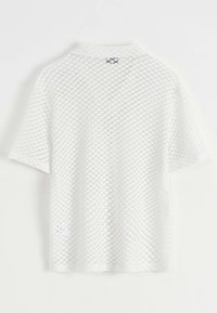 Chemise blanche à manches courtes avec un motif en mesh en losange. La texture est légère et aérienne, avec un col simple et un logo dans le dos.