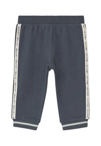 Grijze sportbroek van een zachte stof, met een elastische tailleband, contrasterende boorden en zijstrepen met de tekst "CLUB FITNESS".