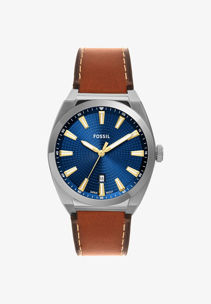 Montre-bracelet Fossil pour homme avec cadran bleu texturé, index et aiguilles dorés, guichet date à 6 heures, et bracelet en cuir marron.