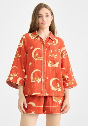 Orange two-piece pajama set featuring short-sleeve button-up top and shorts. Printed with foxes, moons, and stars; soft, lightweight fabric.