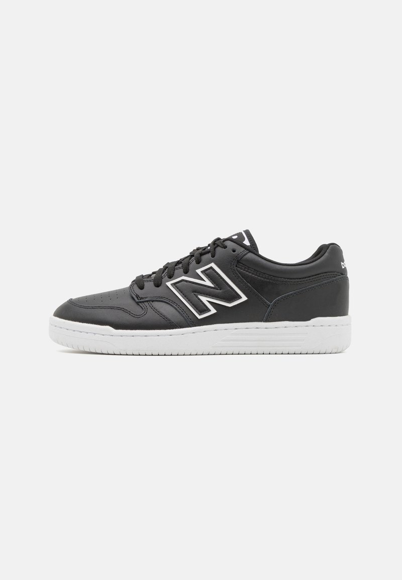 Pantofi sport negri din piele sintetică cu o talpă din cauciuc alb, având un logo alb proeminent și sireturi negre.