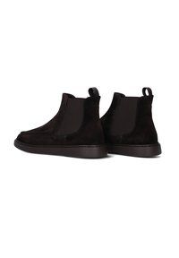 Zwarte suède Chelsea boots hebben elastische zijkanten, een trekhaak, een platte rubberen zool en een strak ontwerp.